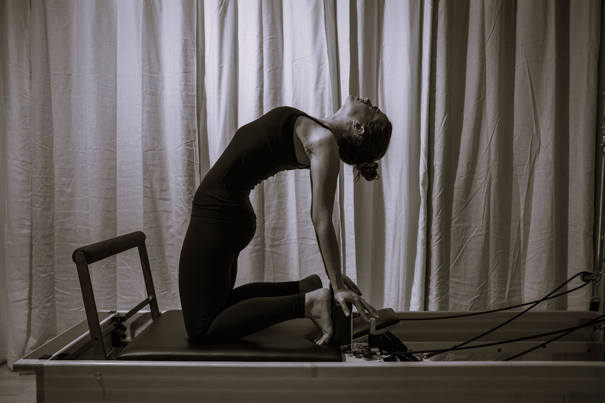 Kelly demonstrating a backbend on the Pilates reformer in the Fit Monkeys studio.